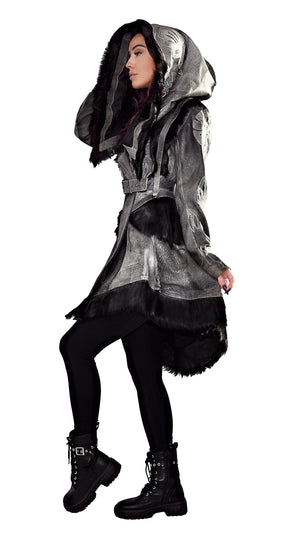 A hooded jacket with leather applique details, featuring a fur lining at the hood and a black exterior. The model is posing with one foot raised, wearing black boots and dark tights.